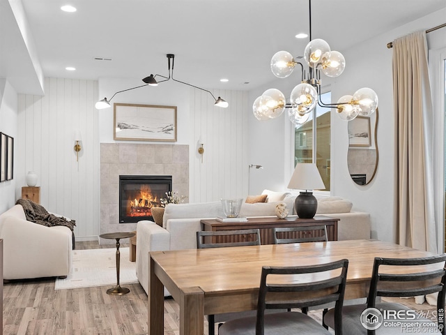 2412 Cottongrass Ave, Loveland, CO 80538 - dining area featuring a fireplace, visible vents, light wood-style flooring, and recessed lighting