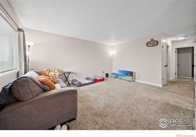 interior space with carpet flooring, baseboards, and a textured ceiling