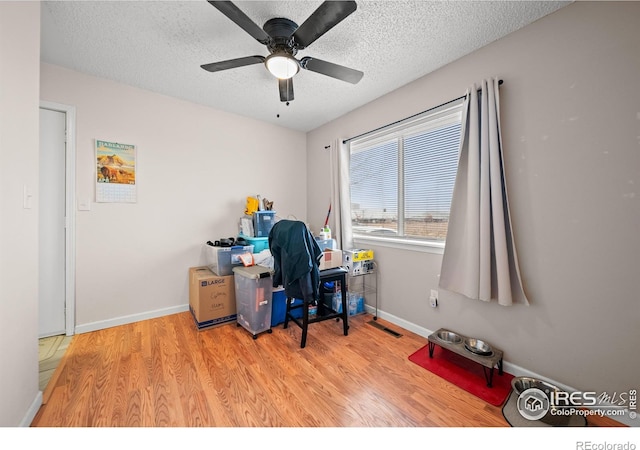 home office with visible vents, baseboards, ceiling fan, a textured ceiling, and wood finished floors