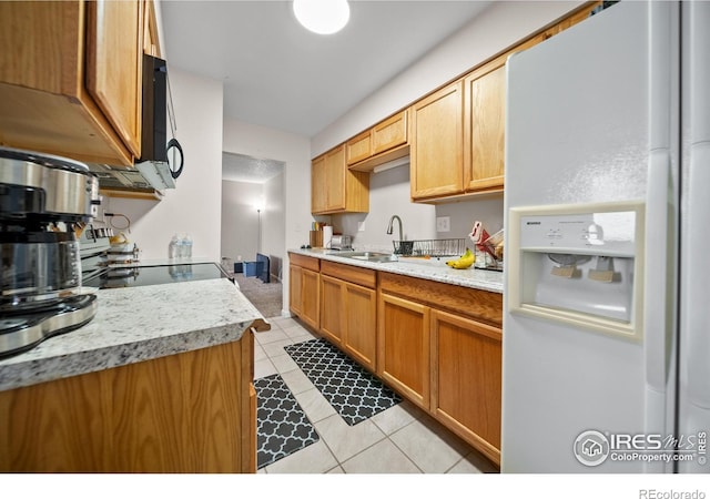 kitchen featuring white refrigerator with ice dispenser, light tile patterned floors, light countertops, and black microwave