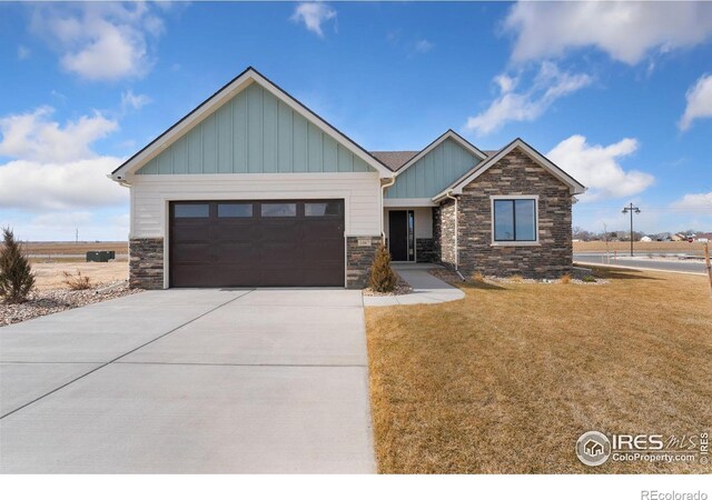 craftsman house featuring a front yard, stone siding, concrete driveway, and an attached garage