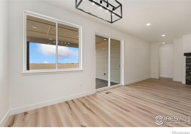 interior space with recessed lighting, baseboards, a fireplace, and wood finished floors