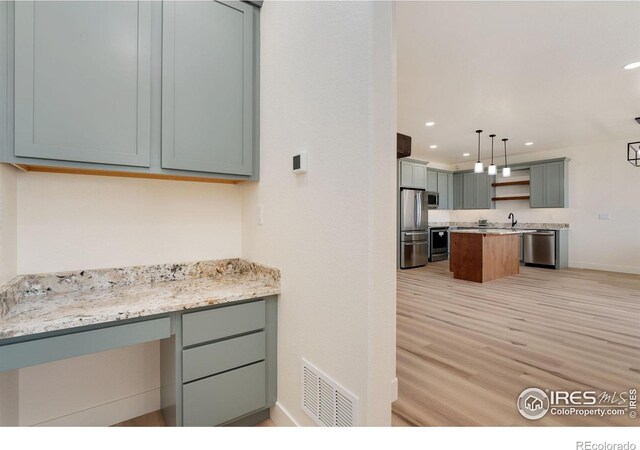 kitchen featuring open shelves, a sink, light wood finished floors, visible vents, and appliances with stainless steel finishes