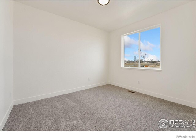 empty room with carpet, baseboards, and visible vents
