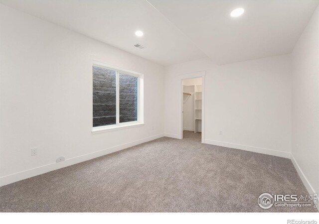 unfurnished bedroom with baseboards, visible vents, recessed lighting, and carpet