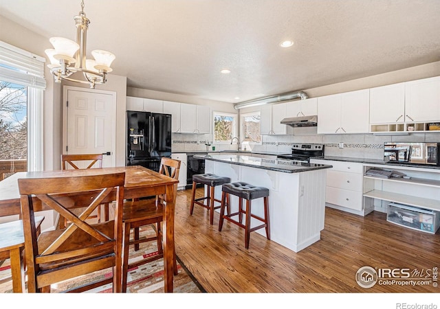2409 Denby Ct, Fort Collins, CO 80526 - kitchen with black appliances, dark countertops, a chandelier, backsplash, and recessed lighting
