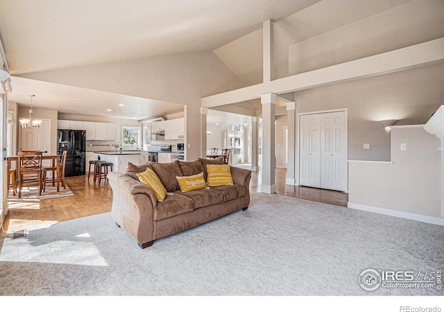 2409 Denby Ct, Fort Collins, CO 80526 - living area featuring light carpet, a chandelier, high vaulted ceiling, baseboards, and decorative columns