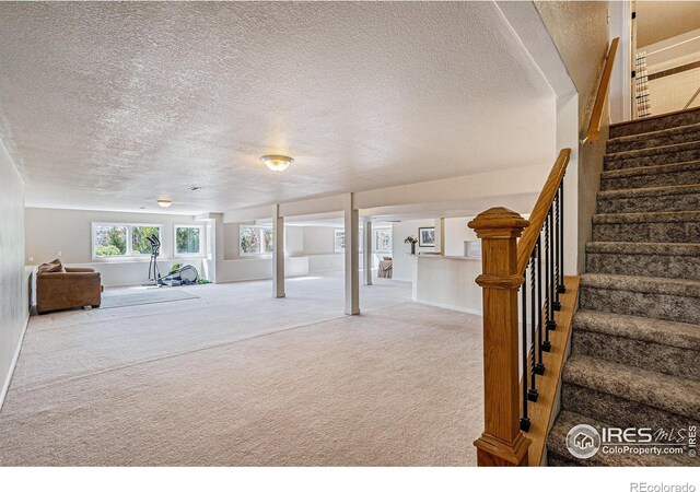 2409 Denby Ct, Fort Collins, CO 80526 - below grade area with a textured ceiling, carpet flooring, stairway, and baseboards