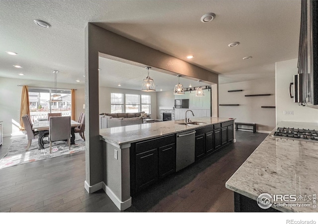kitchen featuring stainless steel appliances, dark cabinetry, baseboards, dark wood-style floors, and a textured ceiling