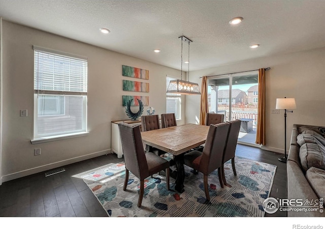 dining space featuring dark wood-style flooring, a textured ceiling, baseboards, and recessed lighting