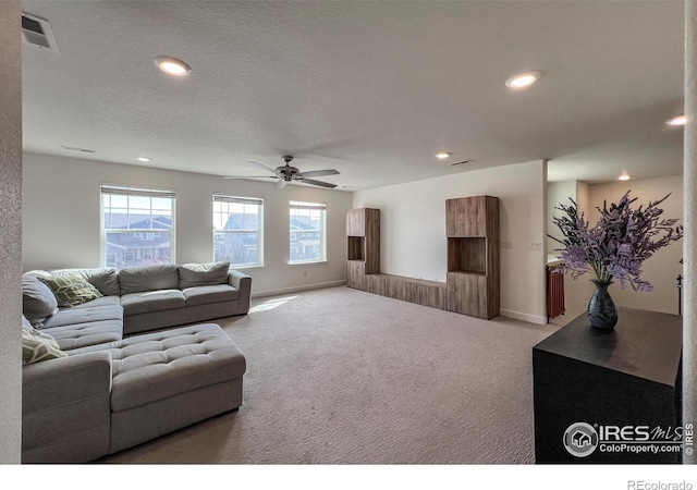 carpeted living room with recessed lighting, a ceiling fan, a textured ceiling, and baseboards