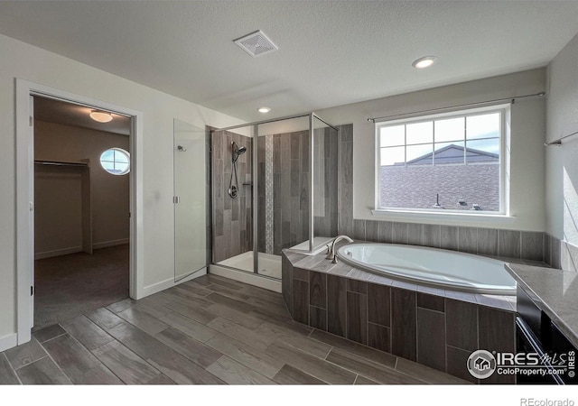 bathroom with a stall shower, a bath, and plenty of natural light