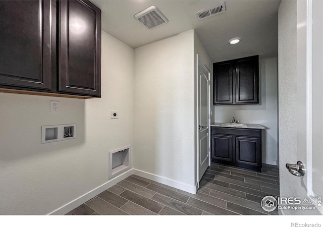 laundry area featuring cabinet space, hookup for a washing machine, baseboards, hookup for an electric dryer, and wood tiled floors