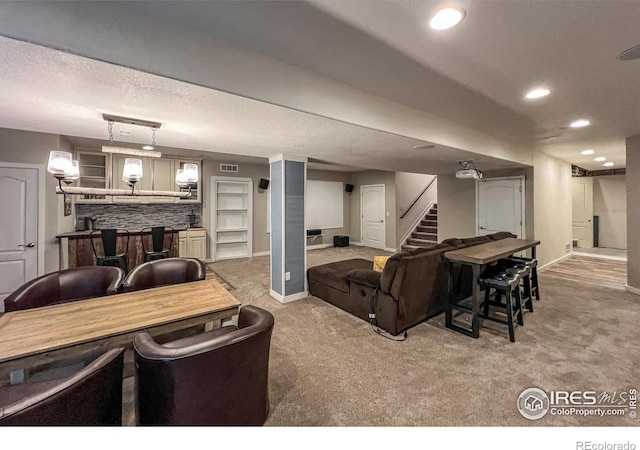 living room featuring a bar, carpet floors, stairs, recessed lighting, and baseboards