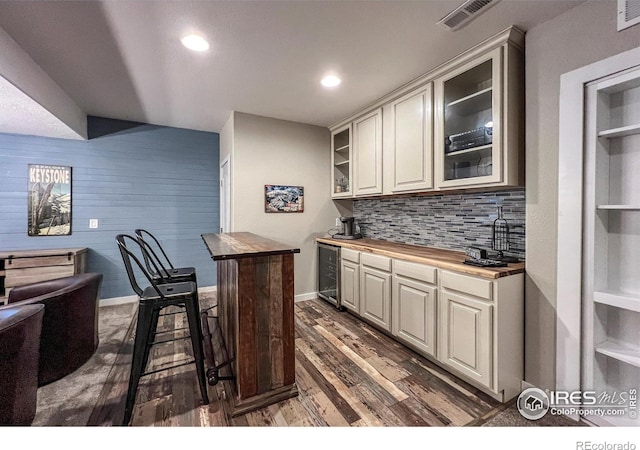 bar with wine cooler, dark wood-type flooring, backsplash, baseboards, and recessed lighting
