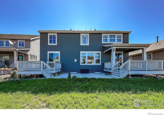 rear view of property with a yard and a wooden deck