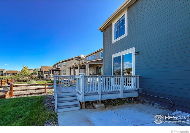 back of property featuring a wooden deck and a residential view