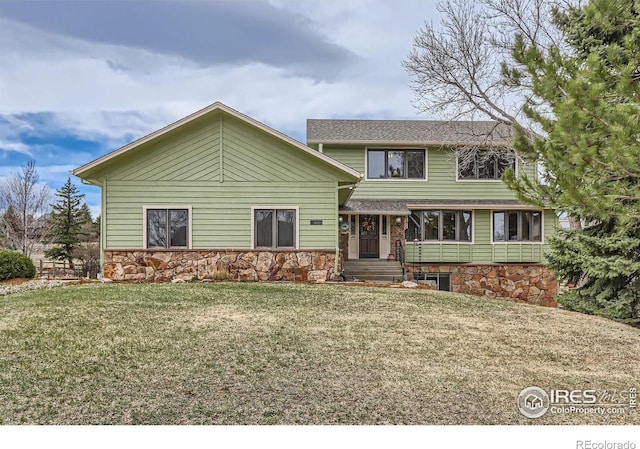 view of front of property featuring stone siding and a front yard