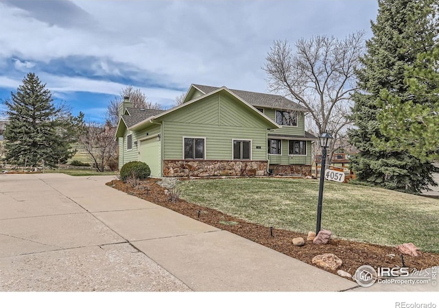 4057 Niblick Dr, Longmont, CO 80503 - view of front of house featuring an attached garage, a front yard, stone siding, a chimney, and concrete driveway