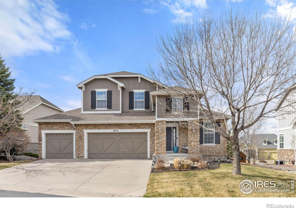 craftsman house featuring a front lawn, stone siding, a garage, and concrete driveway