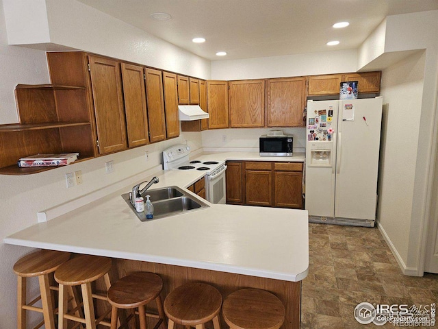 929 Parker Dr, Longmont, CO 80501 - kitchen with white appliances, a sink, open shelves, a peninsula, and brown cabinets