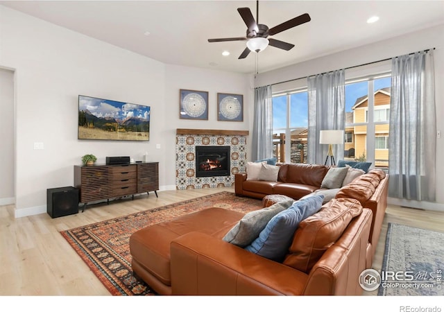 living area with ceiling fan, recessed lighting, wood finished floors, a tile fireplace, and baseboards