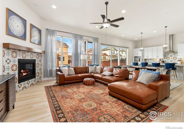 living area with recessed lighting, light wood finished floors, and ceiling fan