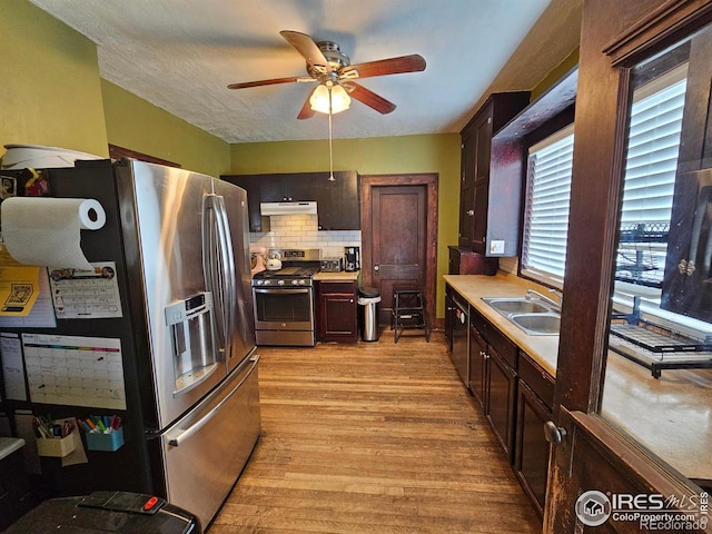 704 S 3rd Ave, Sterling, CO 80751 - kitchen with ceiling fan, light wood-type flooring, light countertops, under cabinet range hood, and stainless steel appliances