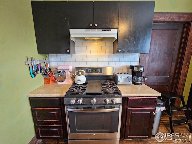 704 S 3rd Ave, Sterling, CO 80751 - kitchen featuring under cabinet range hood, light countertops, gas stove, and tasteful backsplash