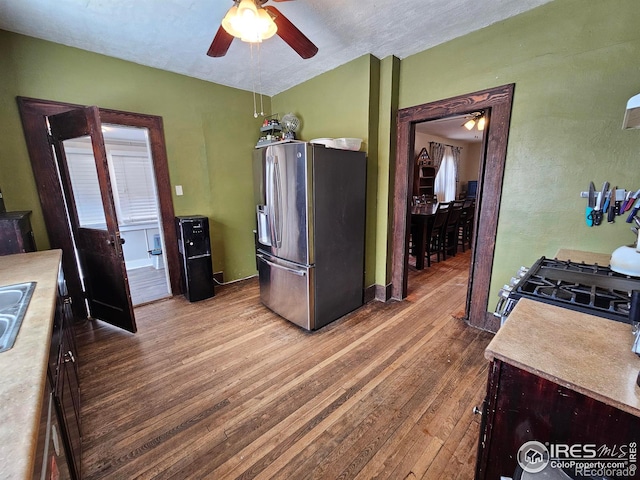 704 S 3rd Ave, Sterling, CO 80751 - kitchen with stainless steel fridge with ice dispenser, ceiling fan, range with gas stovetop, and hardwood / wood-style flooring