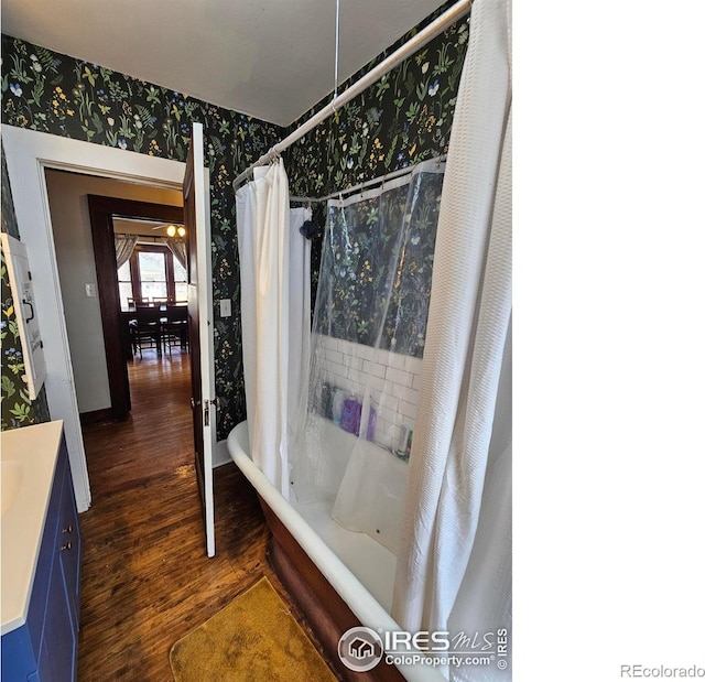 704 S 3rd Ave, Sterling, CO 80751 - bathroom featuring vanity, wallpapered walls, and wood finished floors