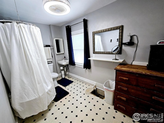 704 S 3rd Ave, Sterling, CO 80751 - full bathroom featuring toilet, baseboards, tile patterned floors, a shower with curtain, and a sink