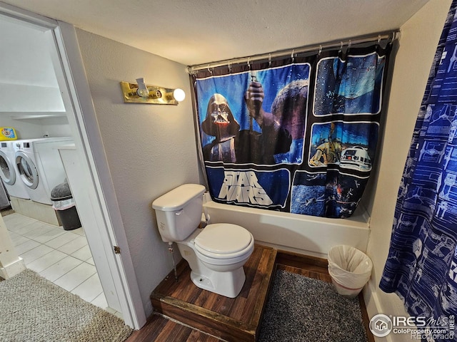 704 S 3rd Ave, Sterling, CO 80751 - bathroom with separate washer and dryer, toilet, shower / bath combination with curtain, baseboards, and wood finished floors