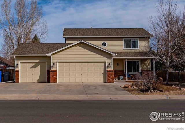 2821 5th St SW, Loveland, CO 80537 - traditional home with covered porch, concrete driveway, brick siding, fence, and an attached garage