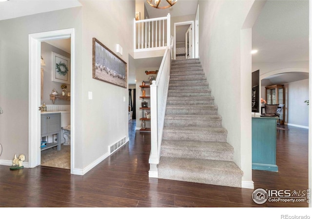 2821 5th St SW, Loveland, CO 80537 - stairs with visible vents, baseboards, wood finished floors, and arched walkways