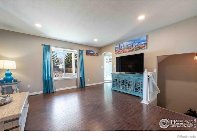 2821 5th St SW, Loveland, CO 80537 - living room featuring arched walkways, wood finished floors, and baseboards