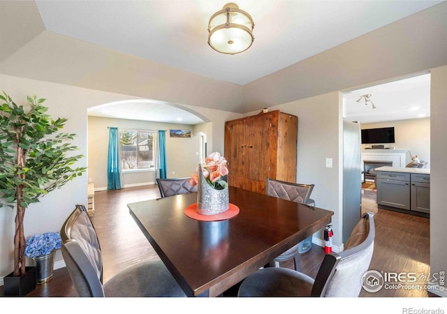 2821 5th St SW, Loveland, CO 80537 - dining space with arched walkways, baseboards, and dark wood-type flooring