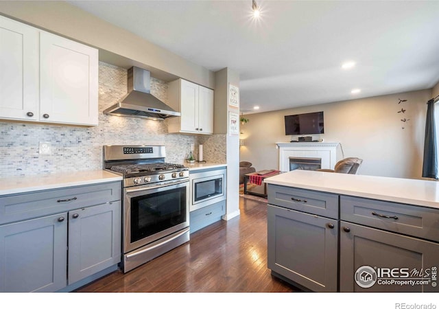 2821 5th St SW, Loveland, CO 80537 - kitchen with gray cabinets, dark wood finished floors, wall chimney exhaust hood, and appliances with stainless steel finishes
