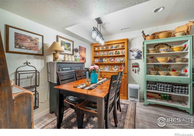 2821 5th St SW, Loveland, CO 80537 - dining area featuring visible vents, wood finished floors, and a textured ceiling