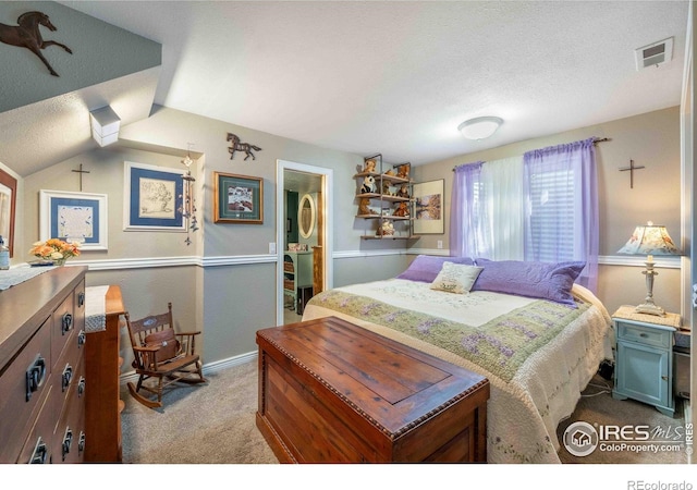 2821 5th St SW, Loveland, CO 80537 - carpeted bedroom featuring a textured ceiling, vaulted ceiling, baseboards, visible vents, and connected bathroom