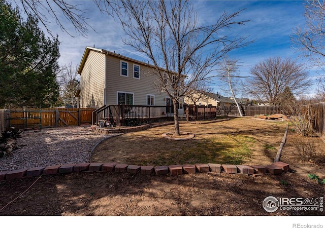 2821 5th St SW, Loveland, CO 80537 - rear view of property with a fenced backyard and a deck