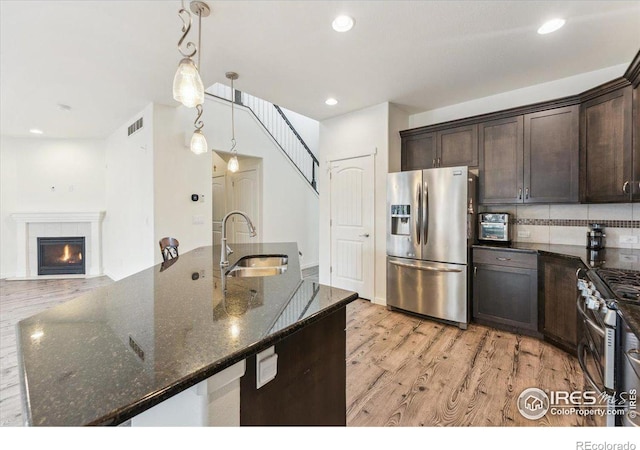 403 S Maple Ave, Eaton, CO 80615 - kitchen featuring stainless steel appliances, a sink, dark brown cabinetry, dark stone countertops, and recessed lighting