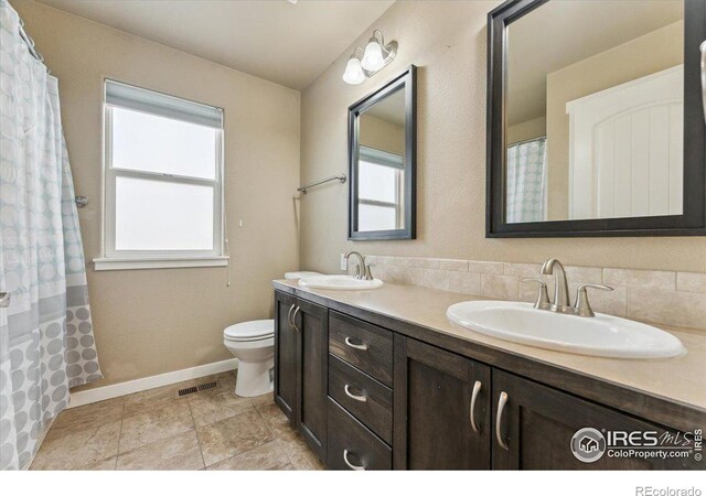 403 S Maple Ave, Eaton, CO 80615 - bathroom with toilet, double vanity, plenty of natural light, and baseboards