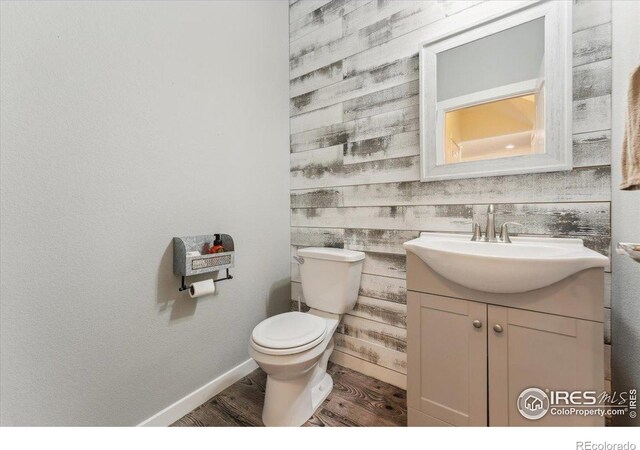 403 S Maple Ave, Eaton, CO 80615 - half bath featuring wood finished floors, vanity, toilet, and baseboards