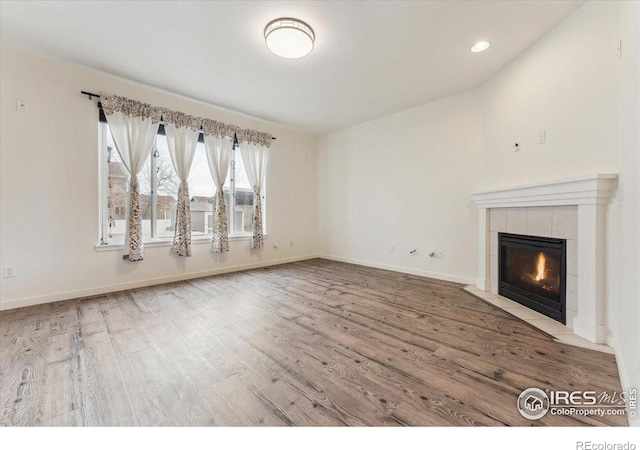 403 S Maple Ave, Eaton, CO 80615 - unfurnished living room featuring wood finished floors, a fireplace, baseboards, and recessed lighting