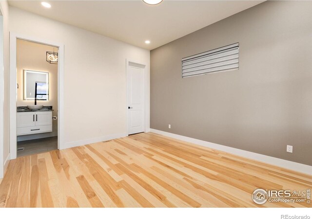 3364 Danzante Bay Ct, Berthoud, CO 80513 - unfurnished bedroom featuring recessed lighting, connected bathroom, light wood-style floors, and baseboards