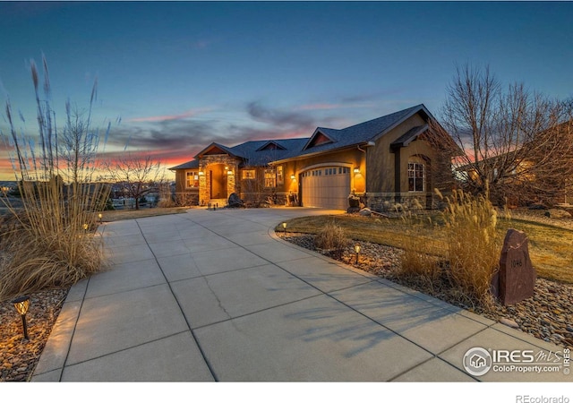 1046 Greens Pl, Erie, CO 80516 - view of front of property with stone siding, an attached garage, driveway, and stucco siding