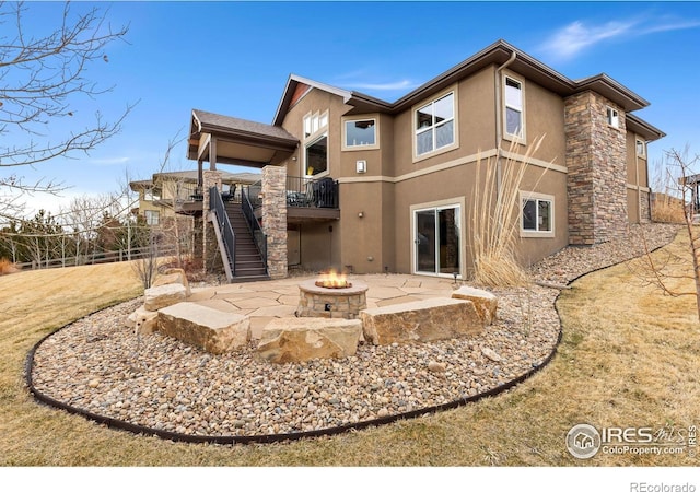 1046 Greens Pl, Erie, CO 80516 - back of property featuring stucco siding, a fire pit, a patio area, stairway, and a wooden deck