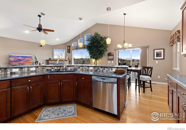 1046 Greens Pl, Erie, CO 80516 - kitchen with dishwasher, a sink, dark countertops, light wood-type flooring, and high vaulted ceiling
