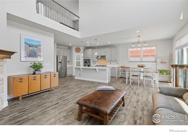 1863 Pioneer Cir, Lafayette, CO 80026 - living room featuring light wood finished floors, a towering ceiling, a chandelier, and recessed lighting